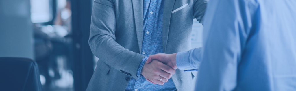 Profissionais em ambiente corporativo a apertar as mãos, simbolizando confiança, transparência e ética nas organizações